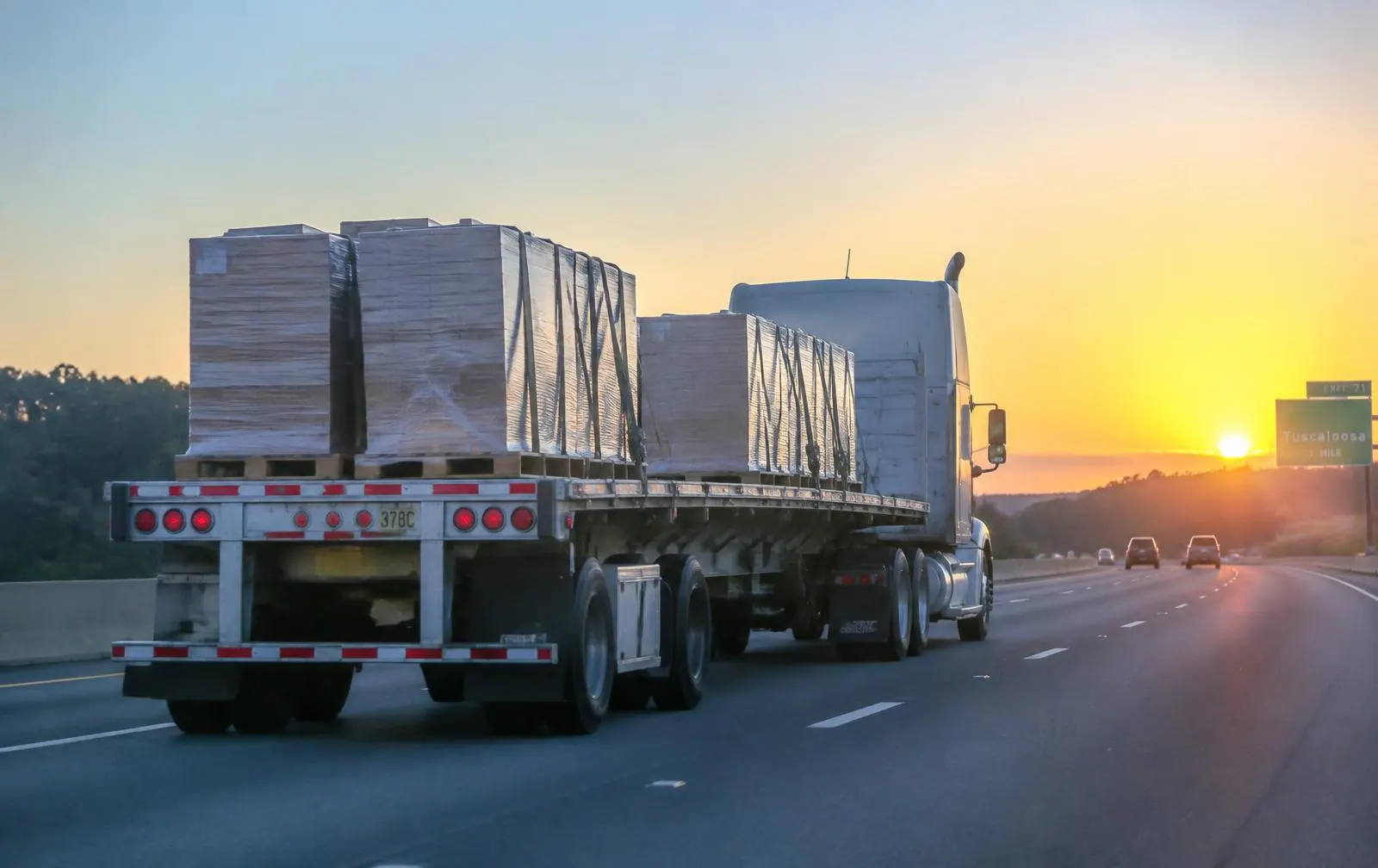 A large freight truck driving on a highway, symbolizing free shipping for Milwaukee overstock pallets